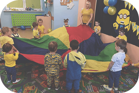 Dzieci bawiące się kolorowym płótnem